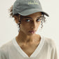 Woman wearing a gray cap with text on a plain background
